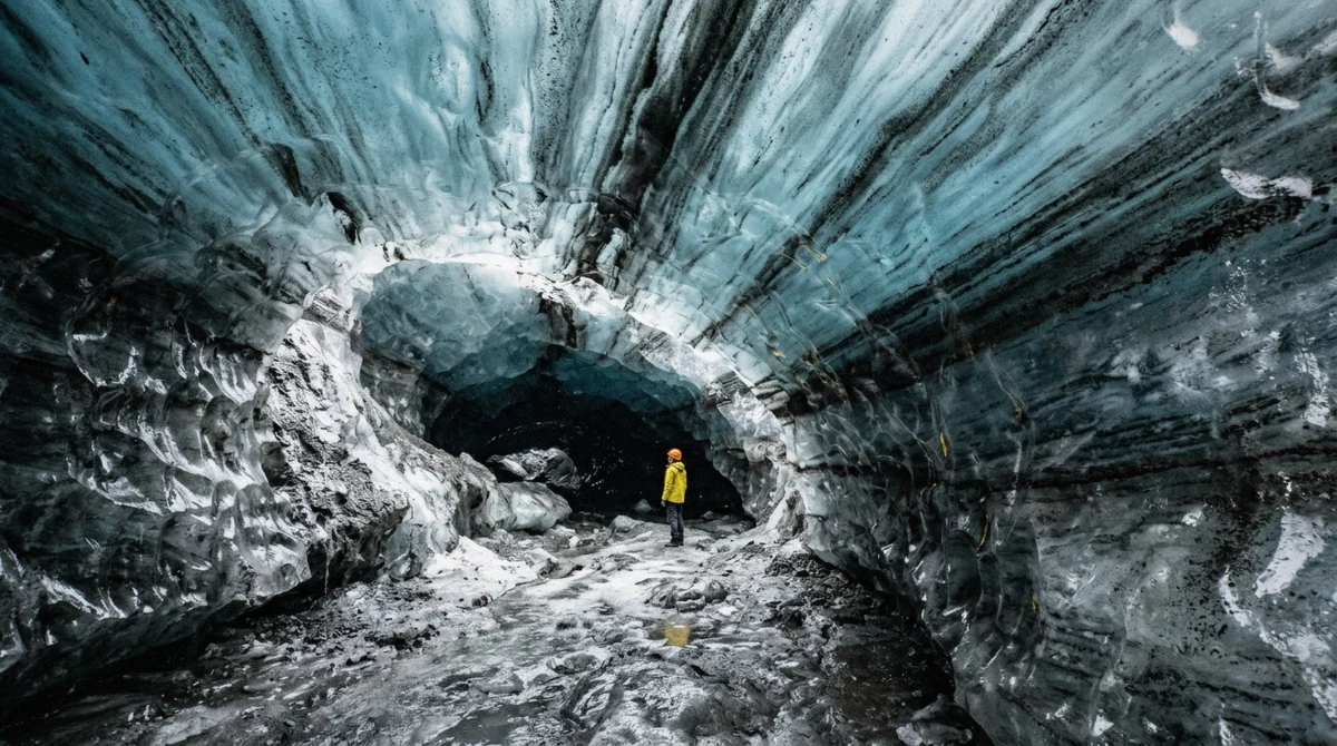 Blue ice banded with black volcanic ash inside the Katla ice cave, the destination of the day tour from Reykjavík